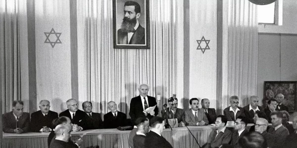 14 maja 1948 r. Premier Dawid Ben-Gurion ogłasza niepodległość Izraela. W tle portret Theodora Herzla. Ministerstwo Spraw Zagranicznych Izraela/Wikipedia, domena publiczna