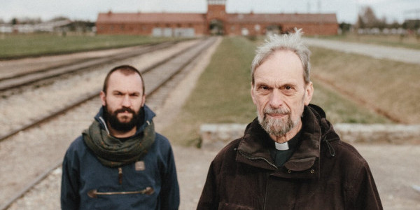 Ks. Manfred Deselaers i Piotr Żyłka przed bramą główną Auschwitz II (Birkenau). Fot. Sebastian Nycz